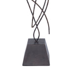 Close-up to a  cast aluminum statues with an oil rubbed bronze finish on a black base, in a minimalist design, portraying abstract curvilinear forms.