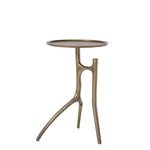 A chair-side table with a brass finish, featuring a single visible leg and a flat, circular top.