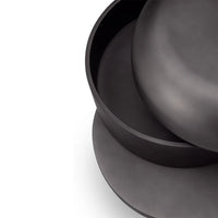 Stack of black ceramic plates on a white background