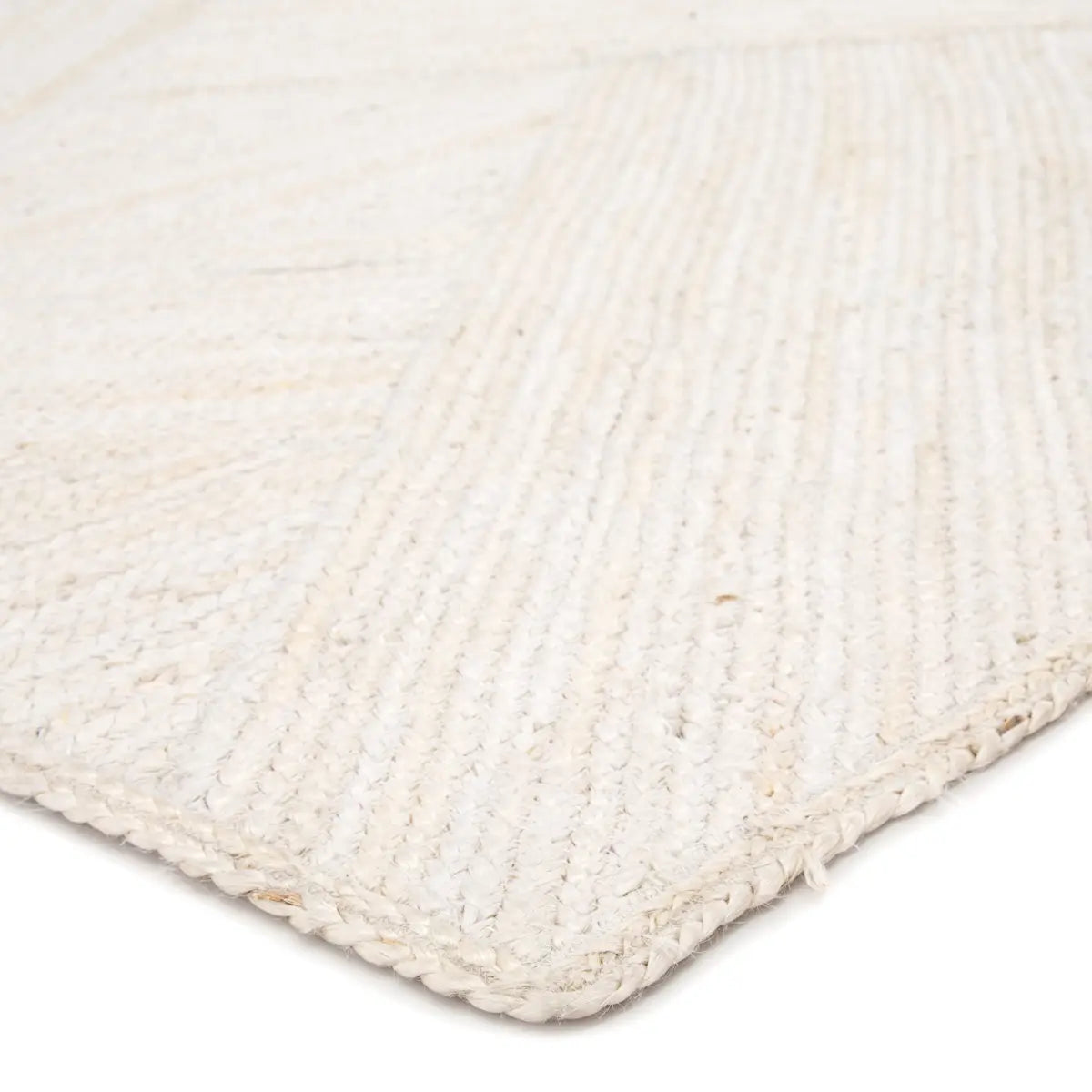Close-up of a braided white rug corner on a light background