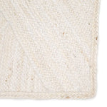 Close-up of a woven beige rug with a textured pattern.