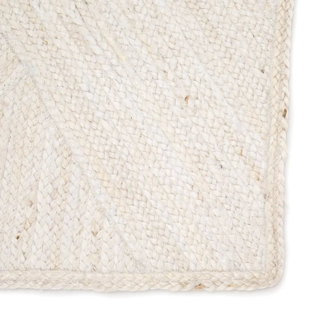 Close-up of a woven beige rug with a textured pattern.