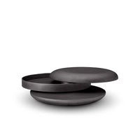 Set of three black ceramic plates stacked on a white background