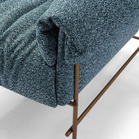 Blue textured sofa with bronze legs on a light gray background