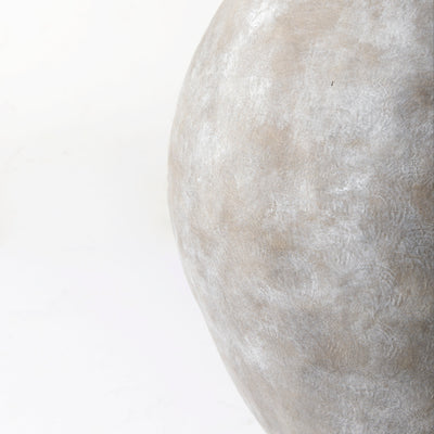 Close-up of a textured stone vase on a white background