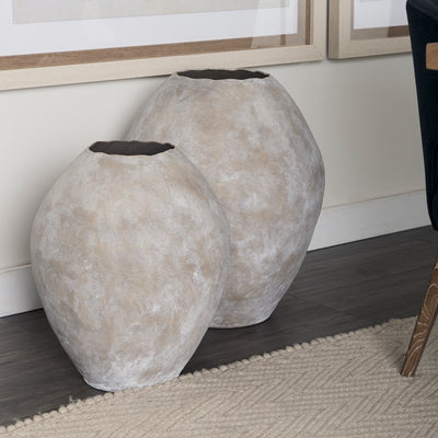 Two gray textured planters on a wooden floor with a neutral wall background.