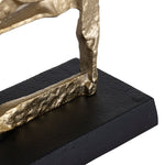 A set of two gold-colored metal decorative objects with a geometric design, placed on a dark base.