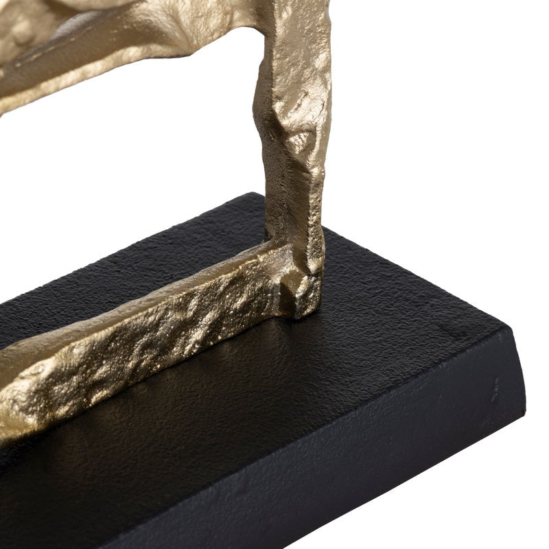 A set of two gold-colored metal decorative objects with a geometric design, placed on a dark base.