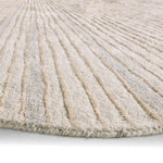 Close-up of a textured beige rug with wavy pattern on a light gray background