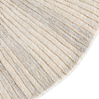 Close-up of a textured rug with horizontal lines in beige and gray.