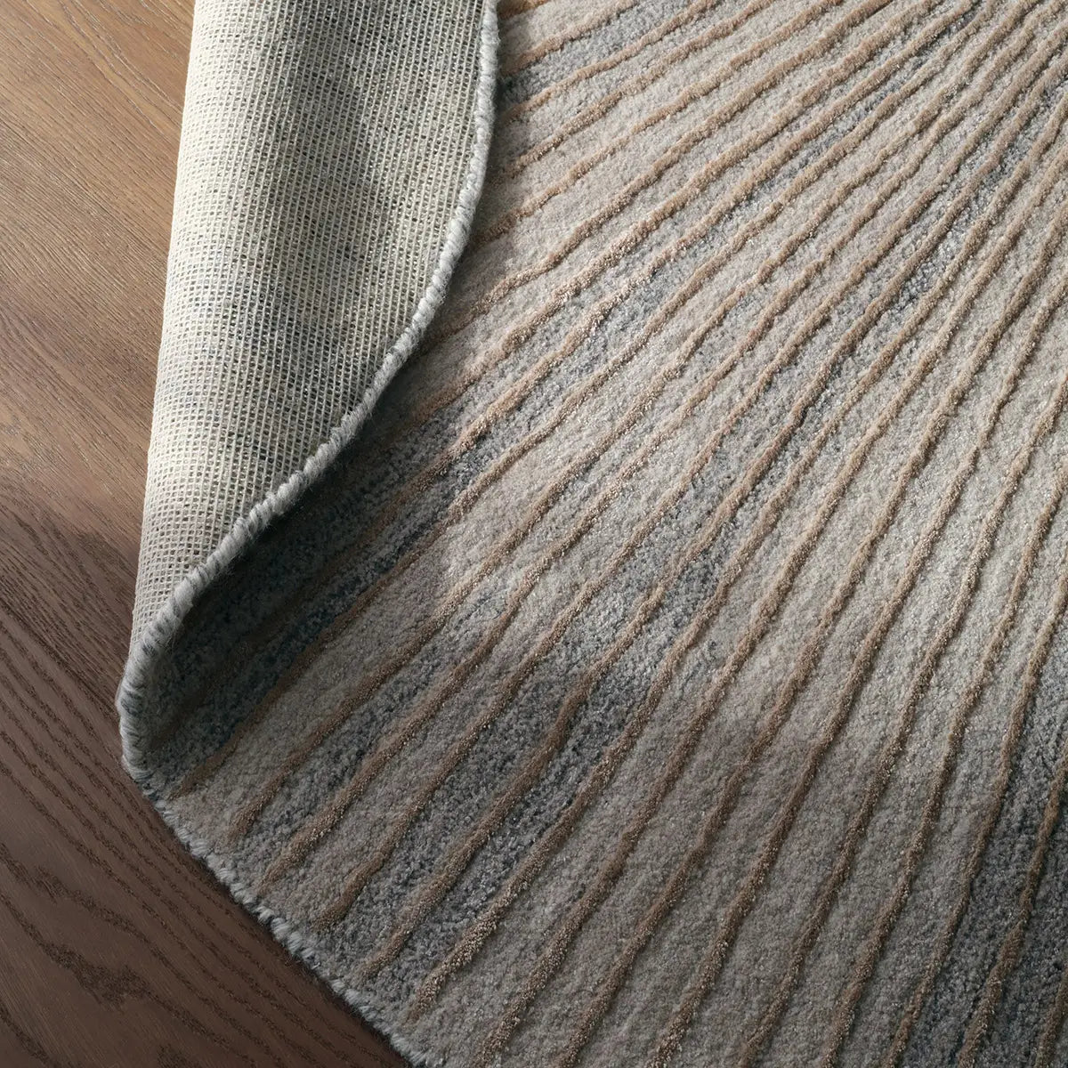 Close-up of a textured gray rug on a wooden floor