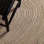 Close-up of textured beige carpet with a black chair leg visible