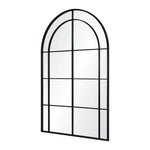 A large full-length mirror with an arched frame and grid-like iron details.