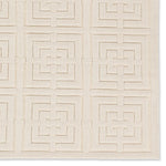 A beige area rug with a geometric pattern