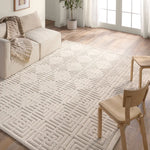 A beige area rug with a geometric pattern