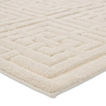 A beige area rug with a geometric pattern