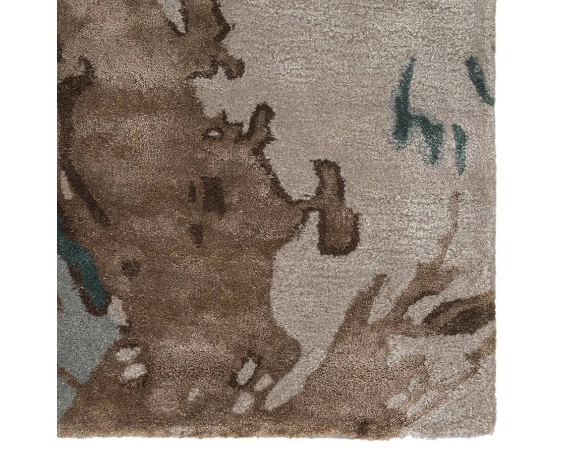 A rectangular area rug featuring a geometric pattern with shades of gray, blue, green, and brown.