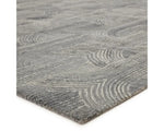A rectangular wool area rug with a geometric pattern in gray, beige, and other colors.
