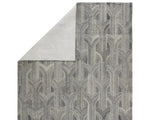 A rectangular wool area rug with a geometric pattern in gray, beige, and other colors.