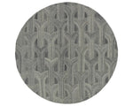 A round wool area rug with a geometric pattern in gray, beige, and other colors.