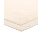 A beige, solid-colored area rug with a visible texture.