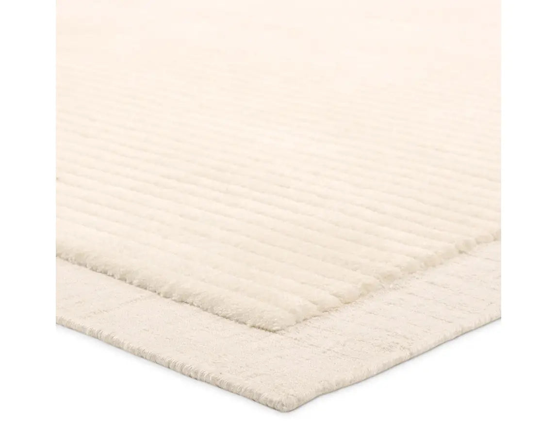 A beige, solid-colored area rug with a visible texture.