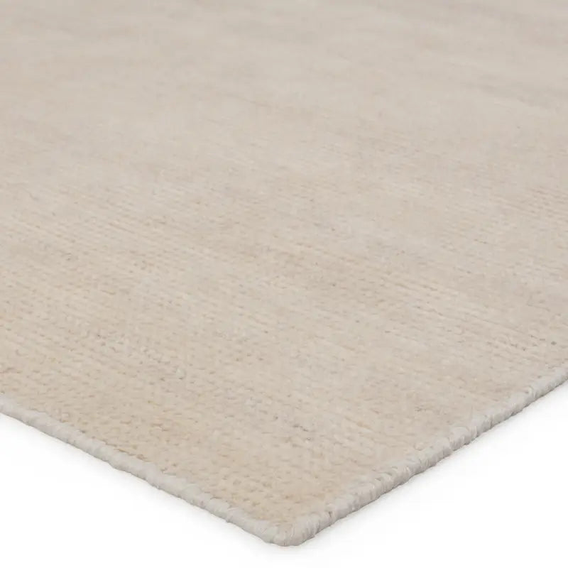 A beige area rug with a flatweave construction, laying on a white background.