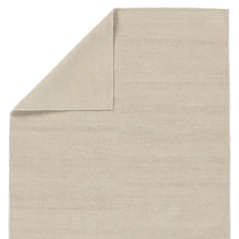 A beige area rug with a flatweave construction, laying on a white background.