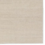 A beige area rug with a flatweave construction, laying on a white background.