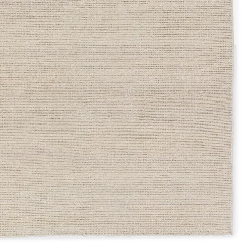 A beige area rug with a flatweave construction, laying on a white background.