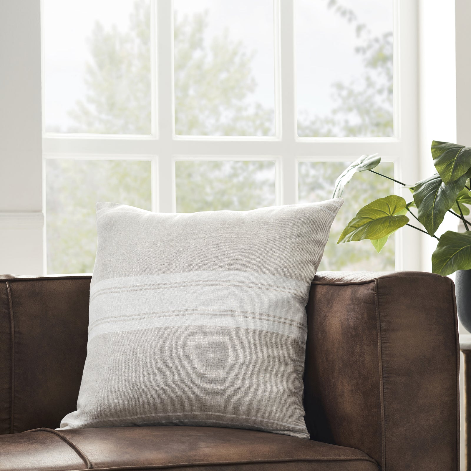 A square-shaped decorative pillow with a double-sided stripe pattern in natural and cream linen colors.