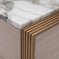 Close-up of a marble countertop with a gold trim on a wooden cabinet.
