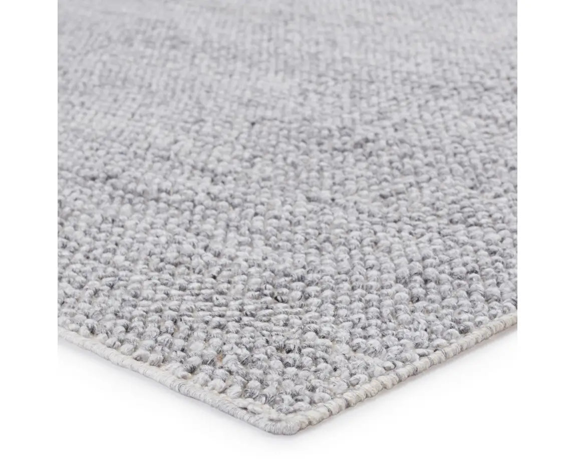 A rectangular, solid gray area rug with a textured weave.