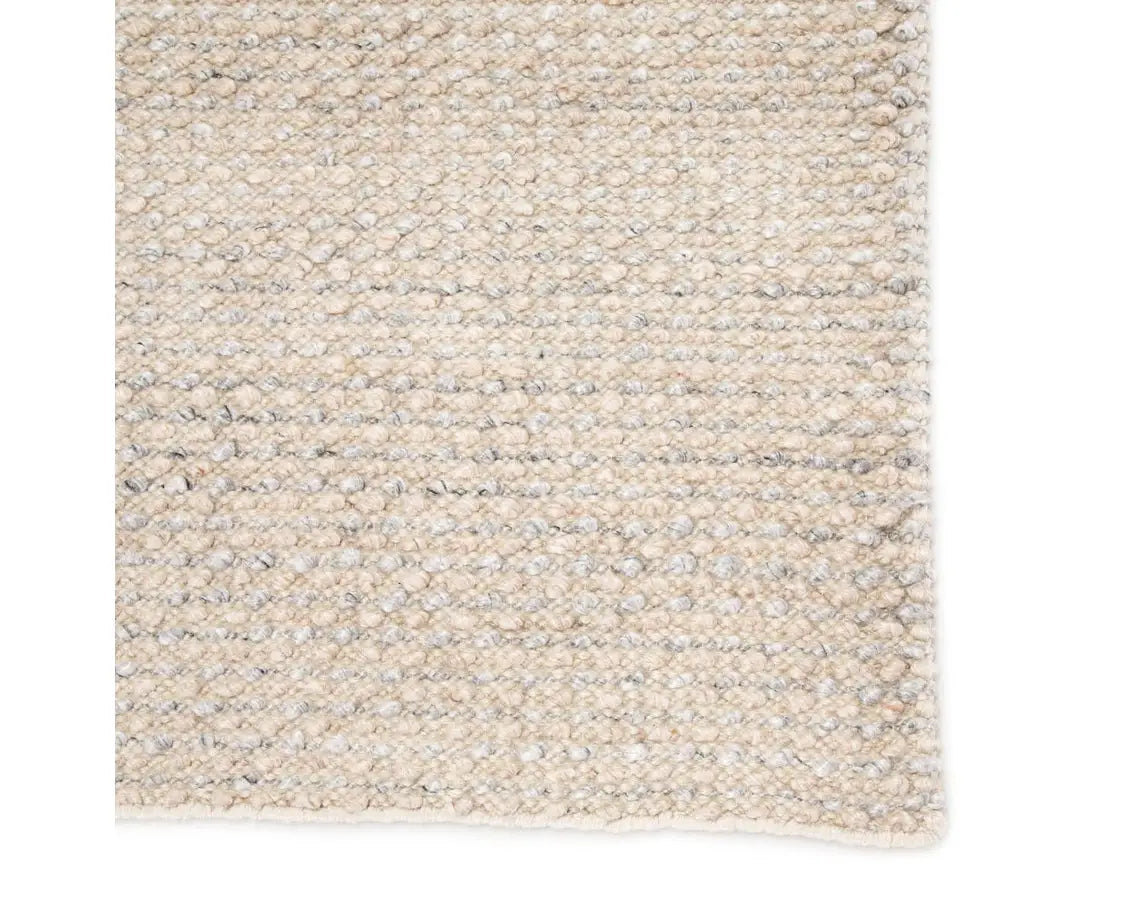 A rectangular area rug in ivory and gray colors, handwoven from 100% polyester yarn.