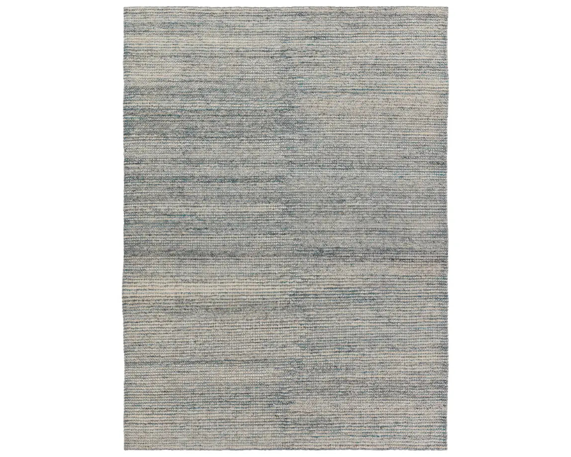 A rectangular area rug with a striped pattern in shades of blue and gray.