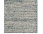 A rectangular area rug with a striped pattern in shades of blue and gray.