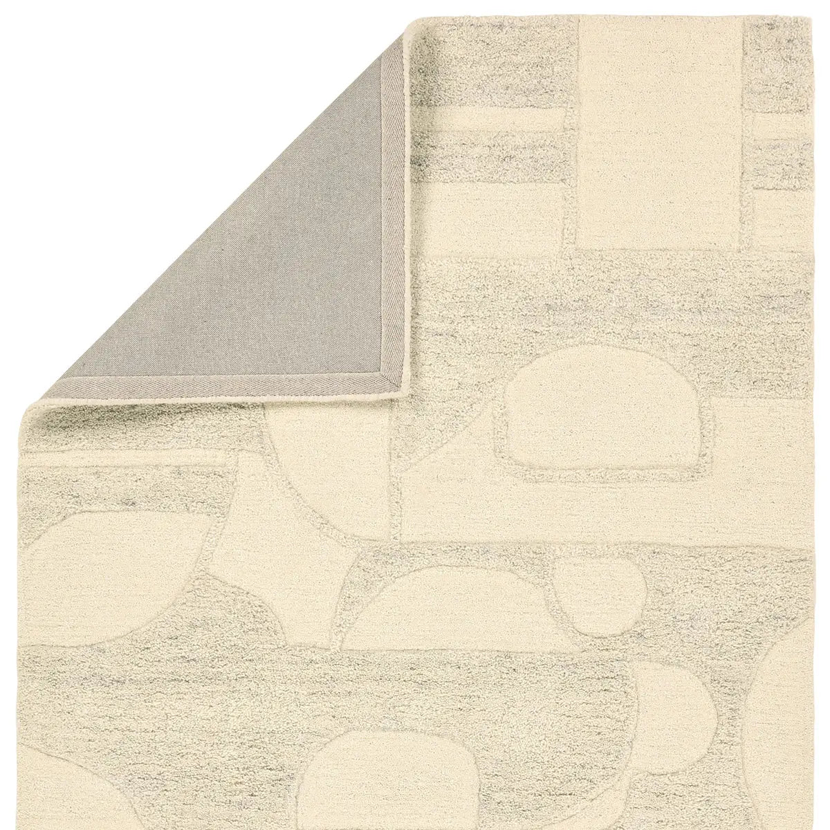 Beige and gray patterned rug corner on a white background