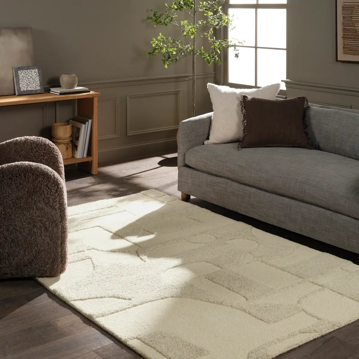 Living room with a gray sofa, armchair, and patterned rug.
