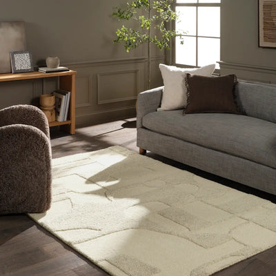 Living room with a gray sofa, armchair, and patterned rug.