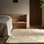 Modern bedroom with wooden headboard, bed, and rug.