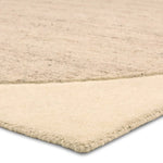 Beige woven rug corner on a white background