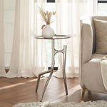 Small round table with decorative vase next to a beige sofa in a bright room.