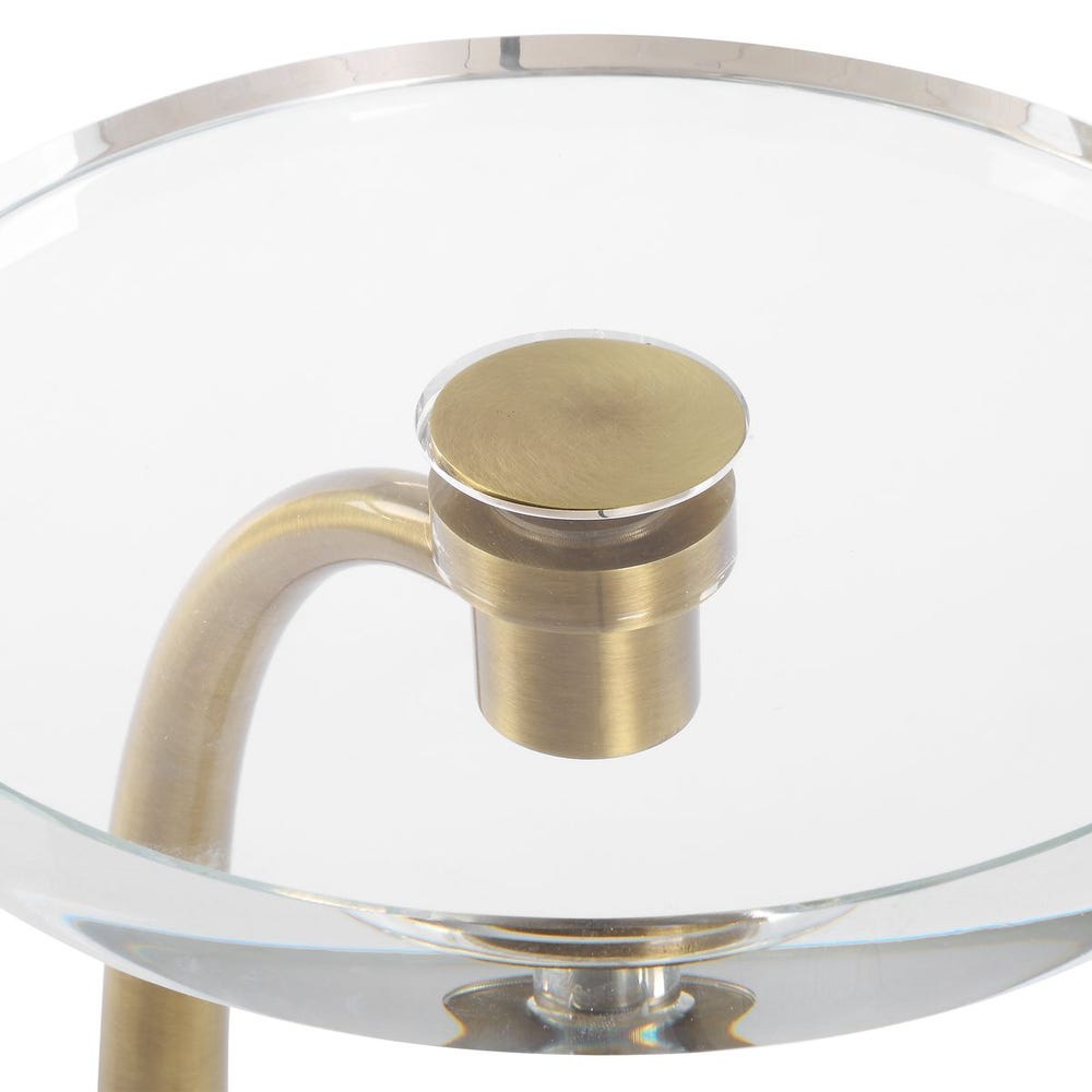 Glass table with gold metal base and clear glass top on a white background
