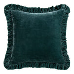 Green velvet pillow with ruffled edges on a white background