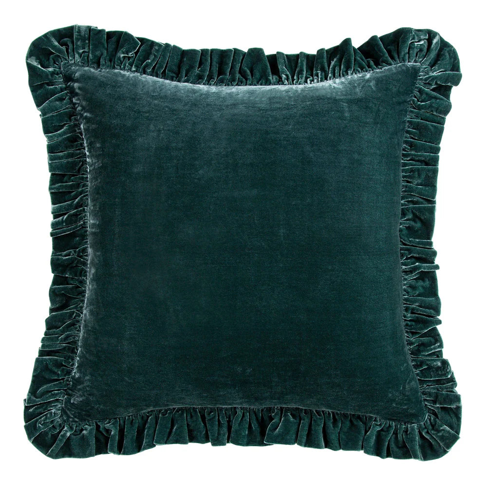 Green velvet pillow with ruffled edges on a white background