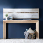 Wooden console table against a blue wall with decorative items.