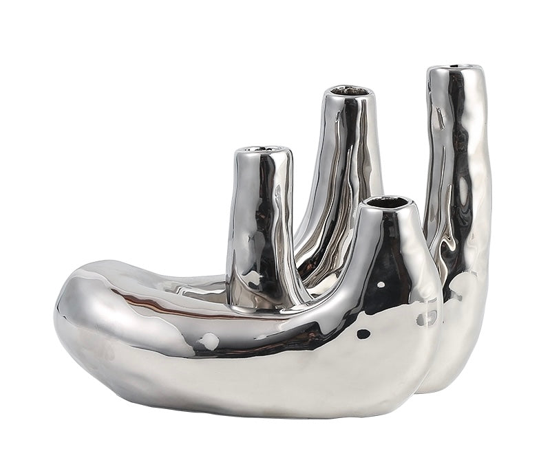 A silver metal candle holder with a sleek, modern design featuring multiple compartments for holding candles.