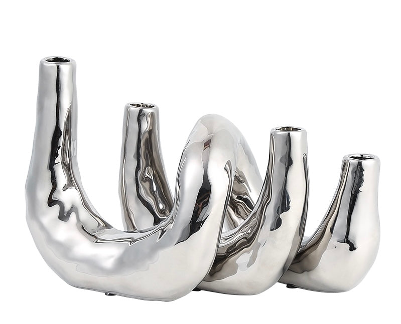 A silver metal candle holder with a sleek, modern design featuring multiple compartments for holding candles.