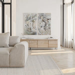 Modern living room with a beige sofa, wooden sideboard, and abstract wall art.