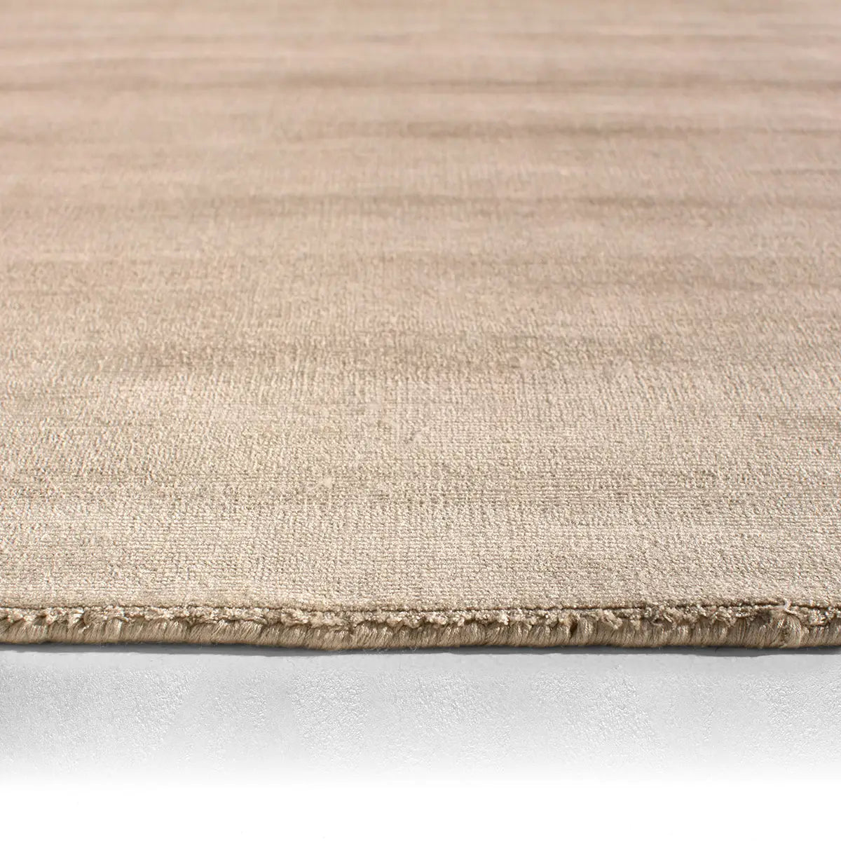 Beige rug with a textured pattern on a white background